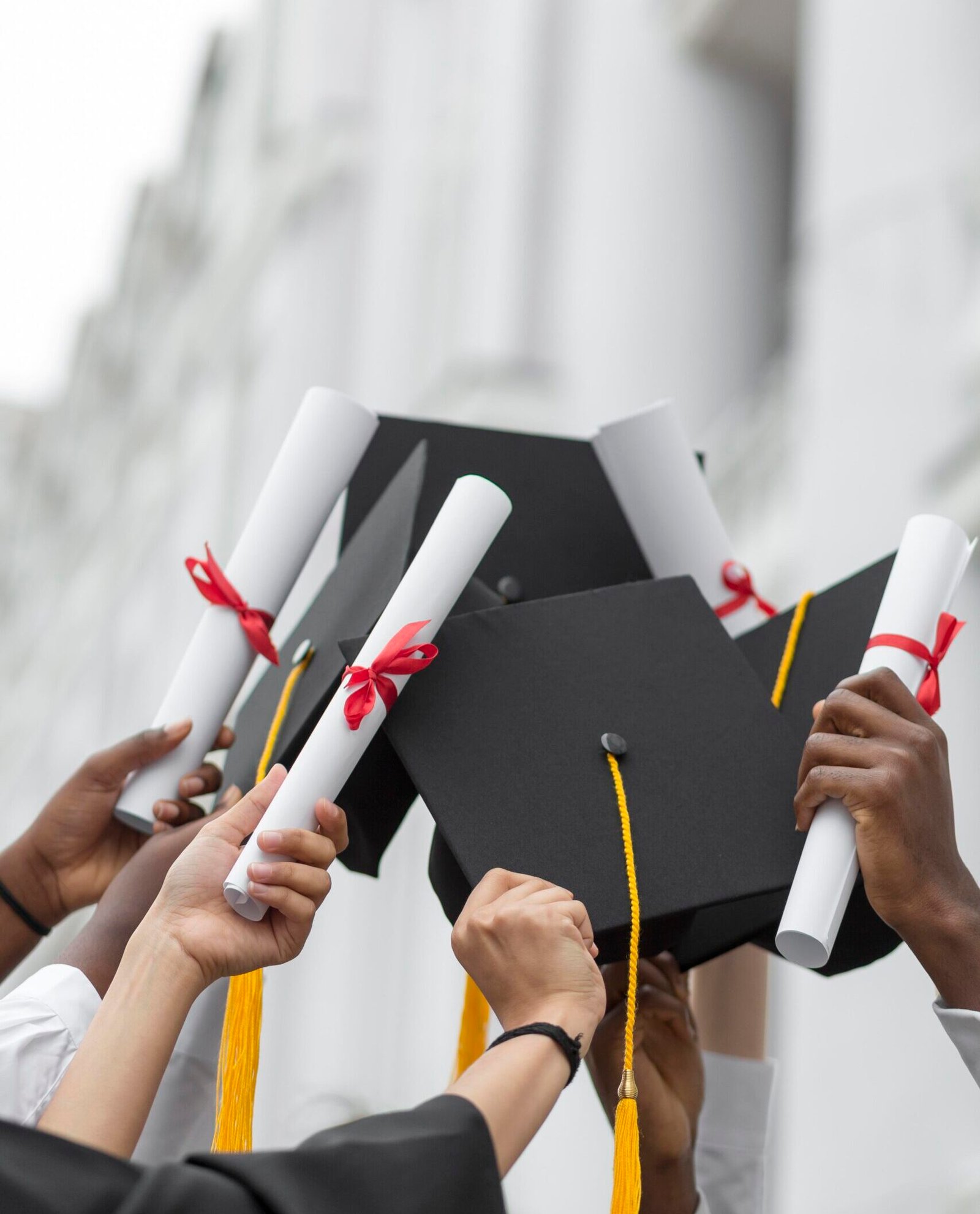 close-up-hands-holding-diplomas-caps - Highridge Education - Highridge Education